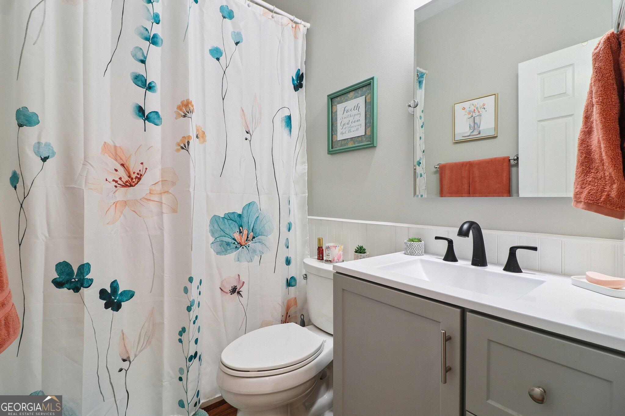 3792 Falls Trail Winston, GA 30187 - Photo 18 of 24 a bathroom with a sink a toilet and a shower curtain