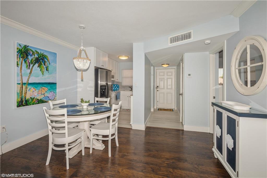 190 Turtle Lake Court, Unit 311 Naples, FL 34105 - Photo 18 of 47 a view of a dining room with furniture a chandelier and wooden floor