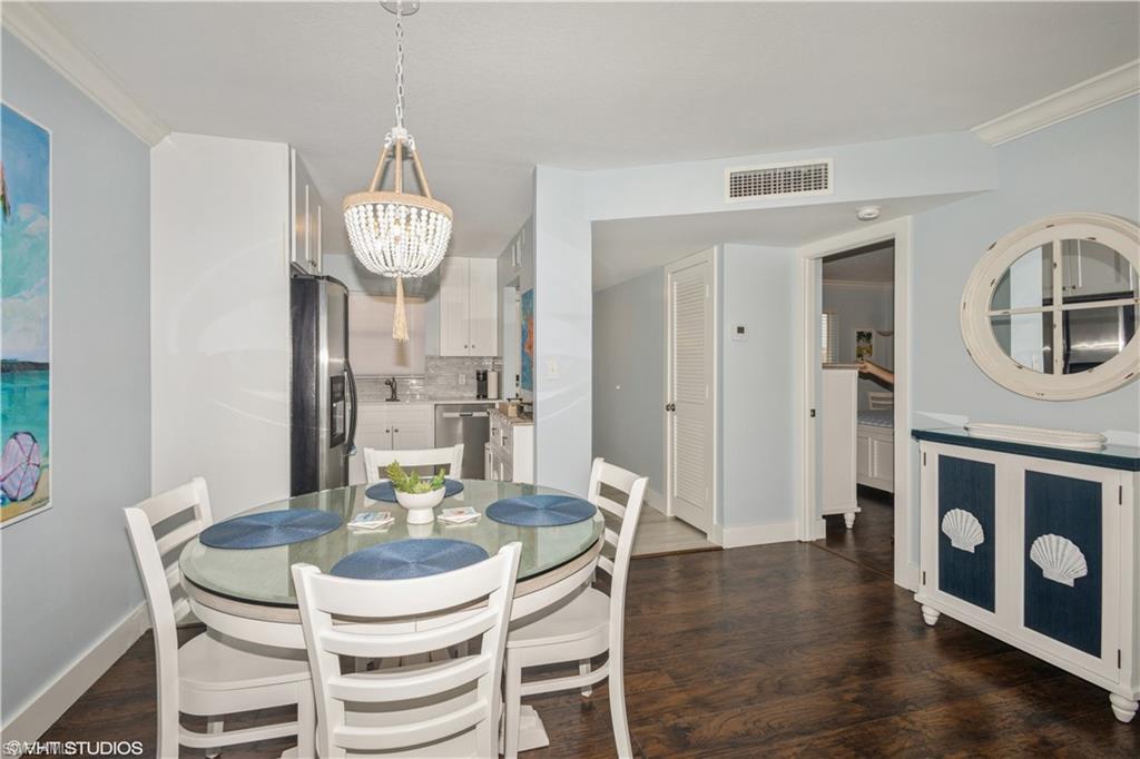 190 Turtle Lake Court, Unit 311 Naples, FL 34105 - Photo 19 of 47 a view of a dining room with furniture a chandelier and wooden floor
