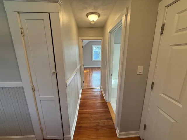 a view of a hallway with wooden floor and staircase