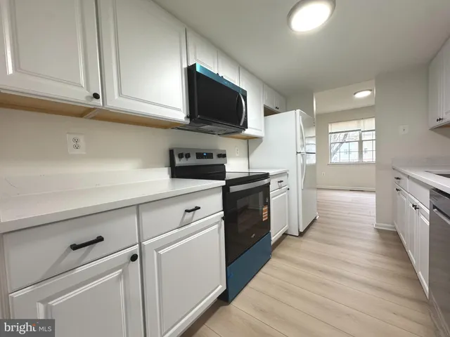 a kitchen with stainless steel appliances granite countertop a stove a sink and a white refrigerator