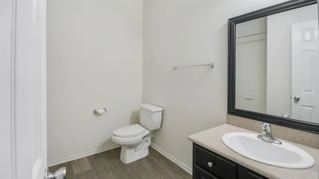 a bathroom with a sink toilet and a mirror