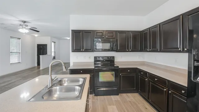 a kitchen with a sink a stove and cabinets