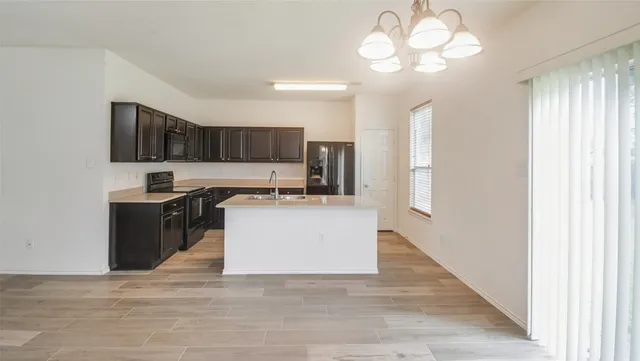 a kitchen with kitchen island granite countertop a stove top oven a sink and dishwasher