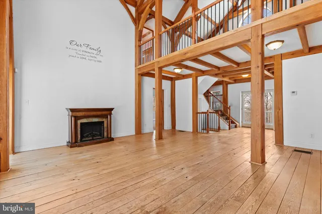 an empty room with wooden floor and a fireplace