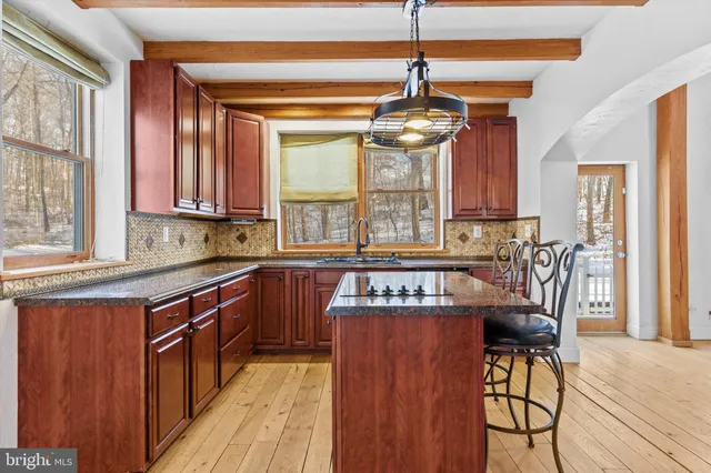 a kitchen with stainless steel appliances granite countertop a sink a stove and cabinets