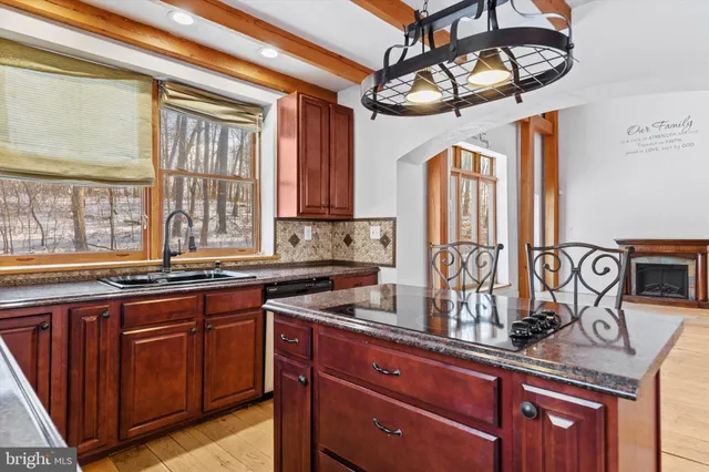 a kitchen with stainless steel appliances granite countertop a stove a refrigerator a oven and a wooden cabinets