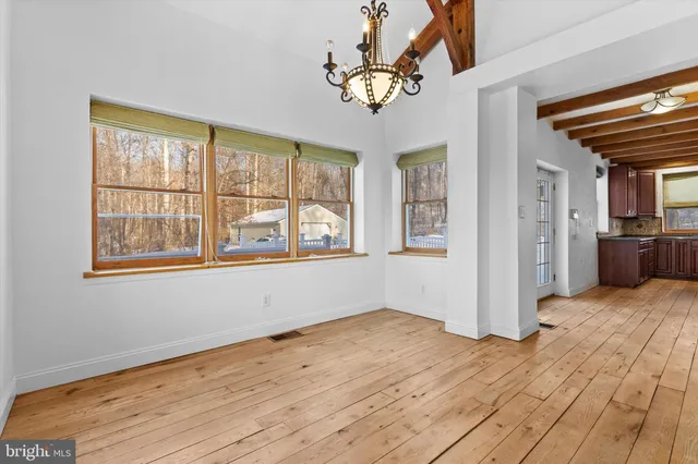 a view of a livingroom with wooden floor and a ceiling fan