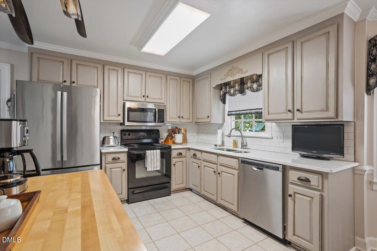 1808 Thorpshire Drive Raleigh, NC 27615 - Photo 6 of 17 a kitchen with stainless steel appliances granite countertop a stove top oven a sink and dishwasher