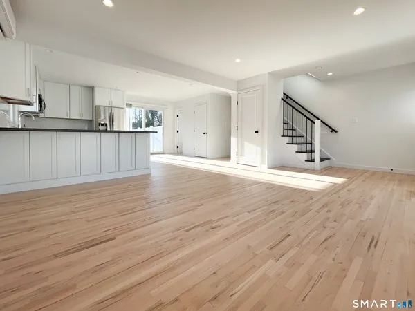a view of a kitchen with wooden floor and electronic appliances
