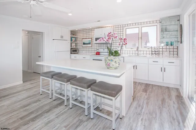 a kitchen with stainless steel appliances white cabinets and wooden floor