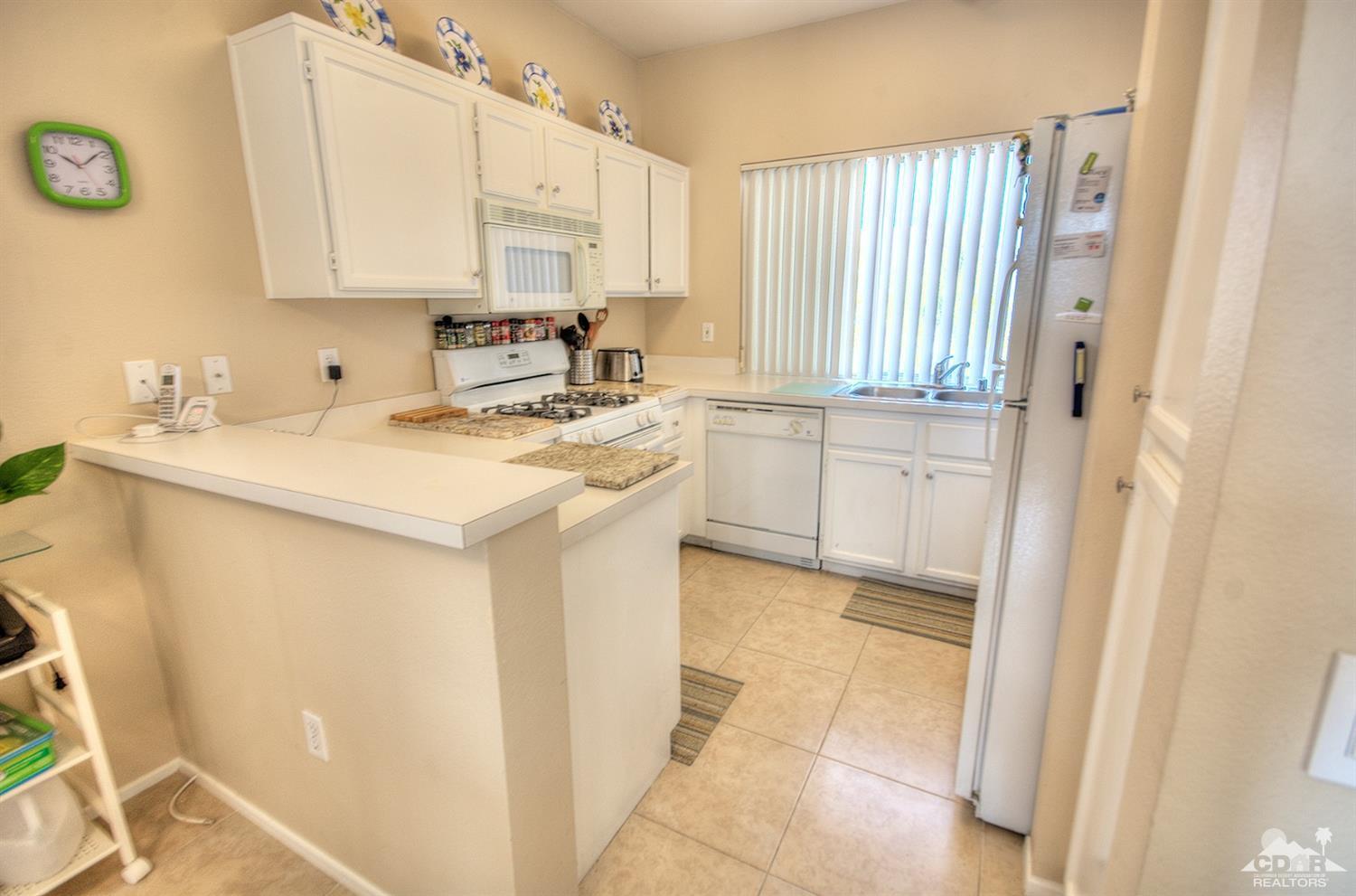38590 Orangecrest Road Palm Desert, CA 92211 - Photo 7 of 23 a kitchen with a sink stove and cabinets