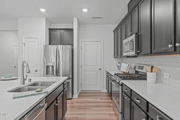 a kitchen with stainless steel appliances a sink stove top oven and cabinets
