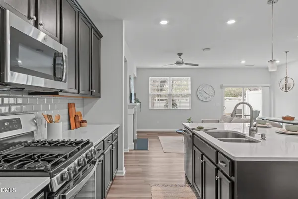 a kitchen with a sink stove and wooden floor