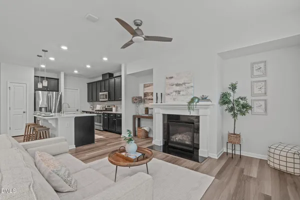 a living room with furniture kitchen view and a fireplace