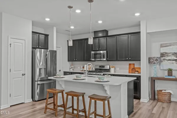a kitchen with kitchen island stainless steel appliances a sink and a refrigerator