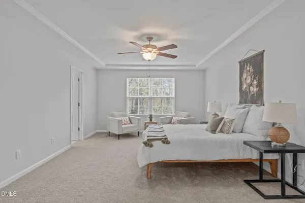 a spacious bedroom with a bed and a chandelier