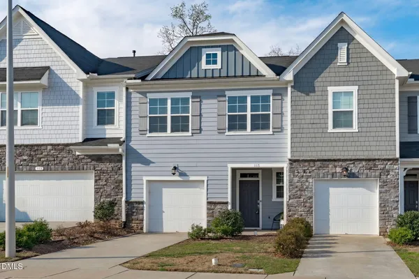 a front view of a house with a potted plant and garage