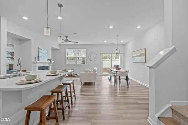 a kitchen with stainless steel appliances granite countertop a stove a sink a microwave a island with a dining table and chairs