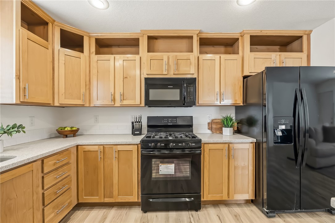 1286 Dike Road Mohave Valley, AZ 86440 - Photo 22 of 35 a kitchen with stainless steel appliances granite countertop a stove a sink and a refrigerator