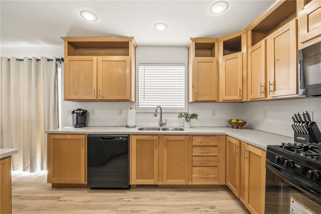 1286 Dike Road Mohave Valley, AZ 86440 - Photo 23 of 35 a kitchen with stainless steel appliances granite countertop a sink stove cabinets and a refrigerator