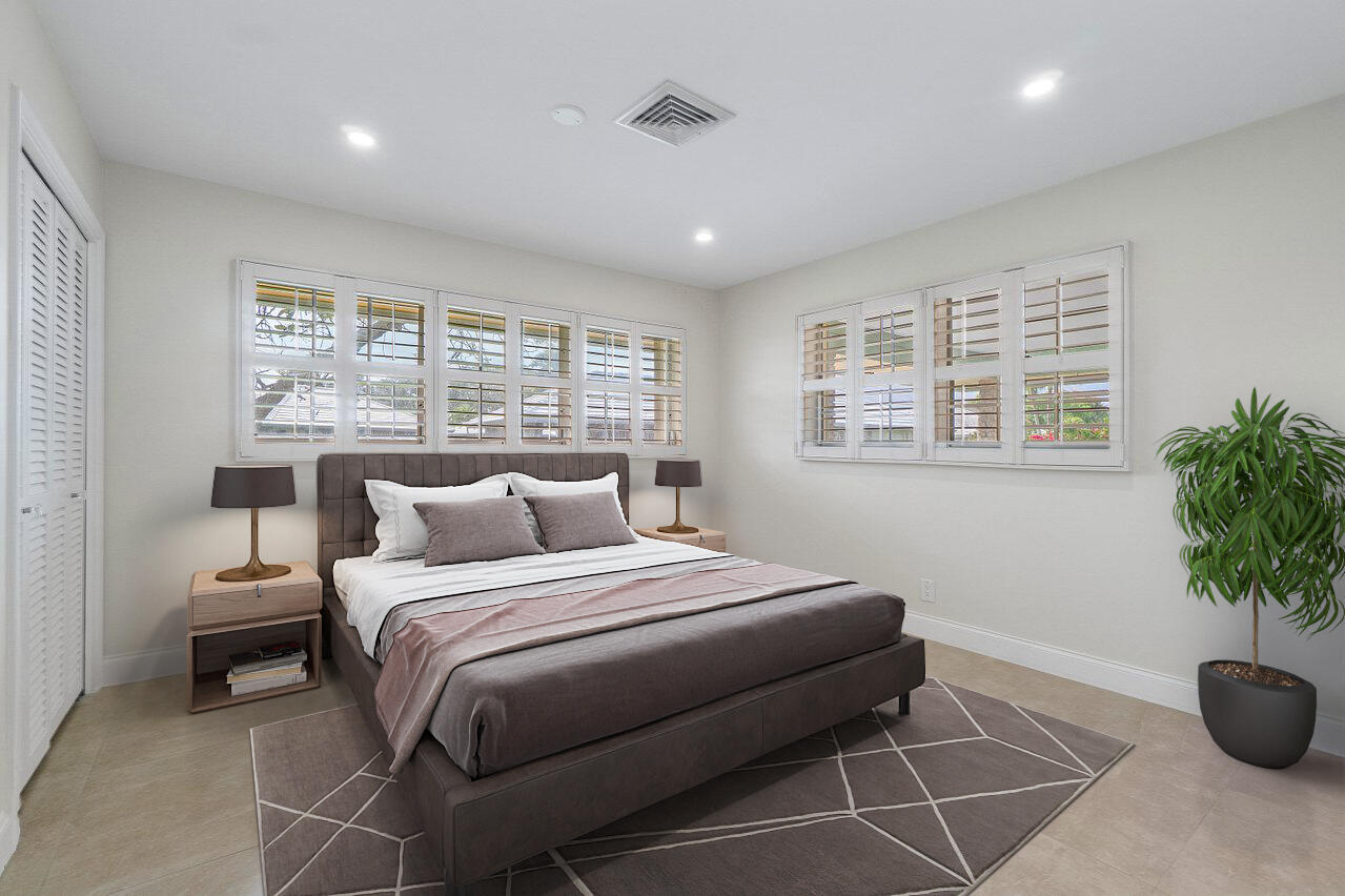 362 Yorktowne Circle Atlantis, FL 33462 - Photo 22 of 41 a bedroom with a large bed and a potted plant