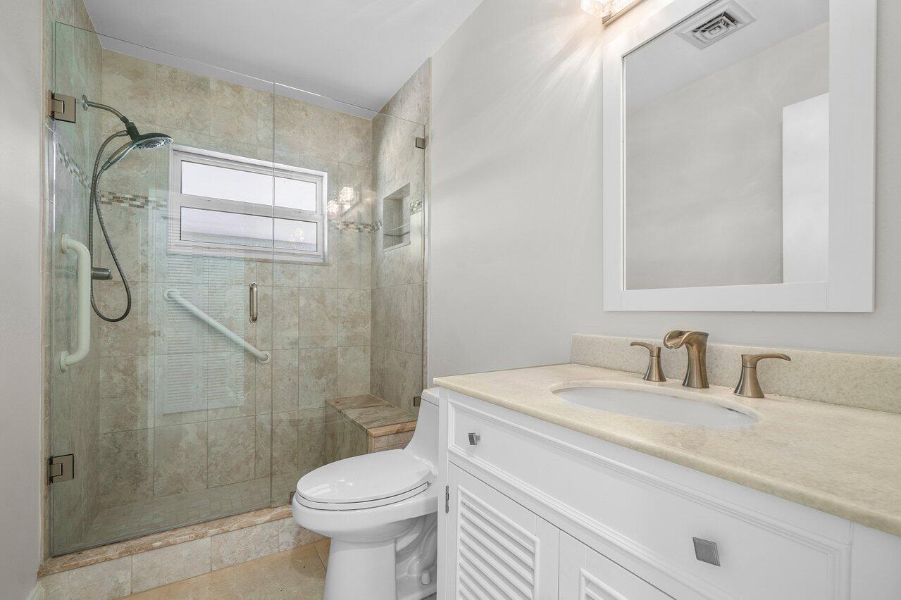 362 Yorktowne Circle Atlantis, FL 33462 - Photo 24 of 41 a bathroom with a granite countertop toilet sink and shower