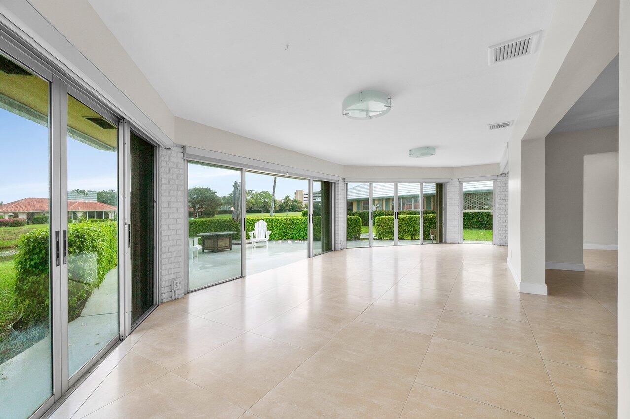 362 Yorktowne Circle Atlantis, FL 33462 - Photo 10 of 41 a view of an empty room with wooden floor and a floor to ceiling window