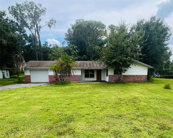 a front view of a house with a yard and trees