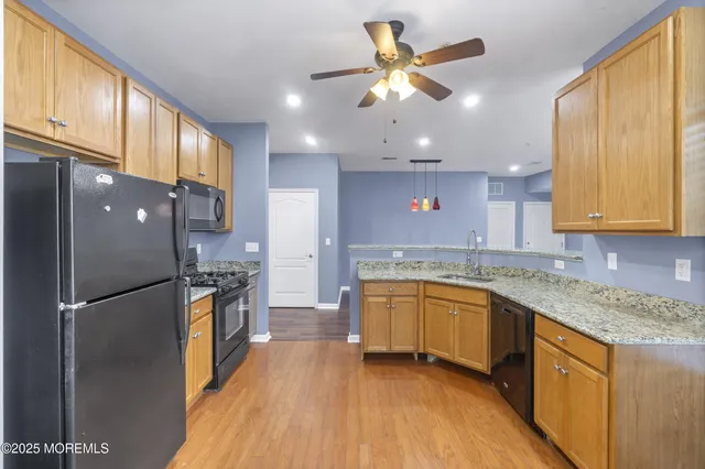 a kitchen with stainless steel appliances granite countertop a sink a stove and a refrigerator