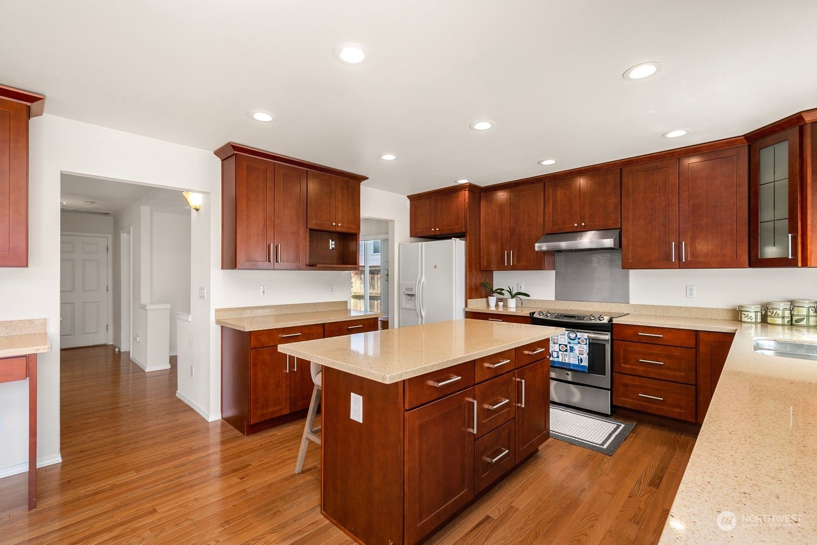 1123 South 34th Street Renton, WA 98055 - Photo 8 of 25 a kitchen with stainless steel appliances kitchen island granite countertop a stove a sink and a refrigerator