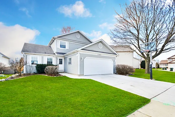 a front view of a house with a yard and garage