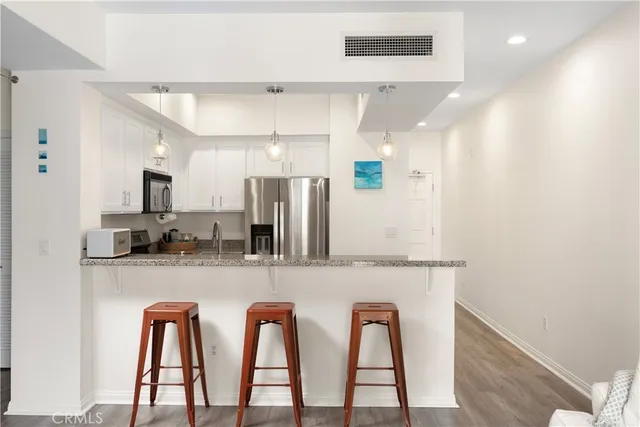 a kitchen with stainless steel appliances a refrigerator and microwave