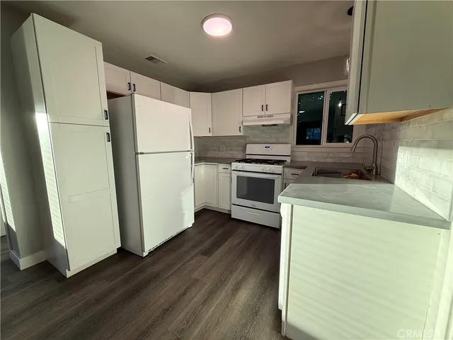 a kitchen with a refrigerator sink and stove