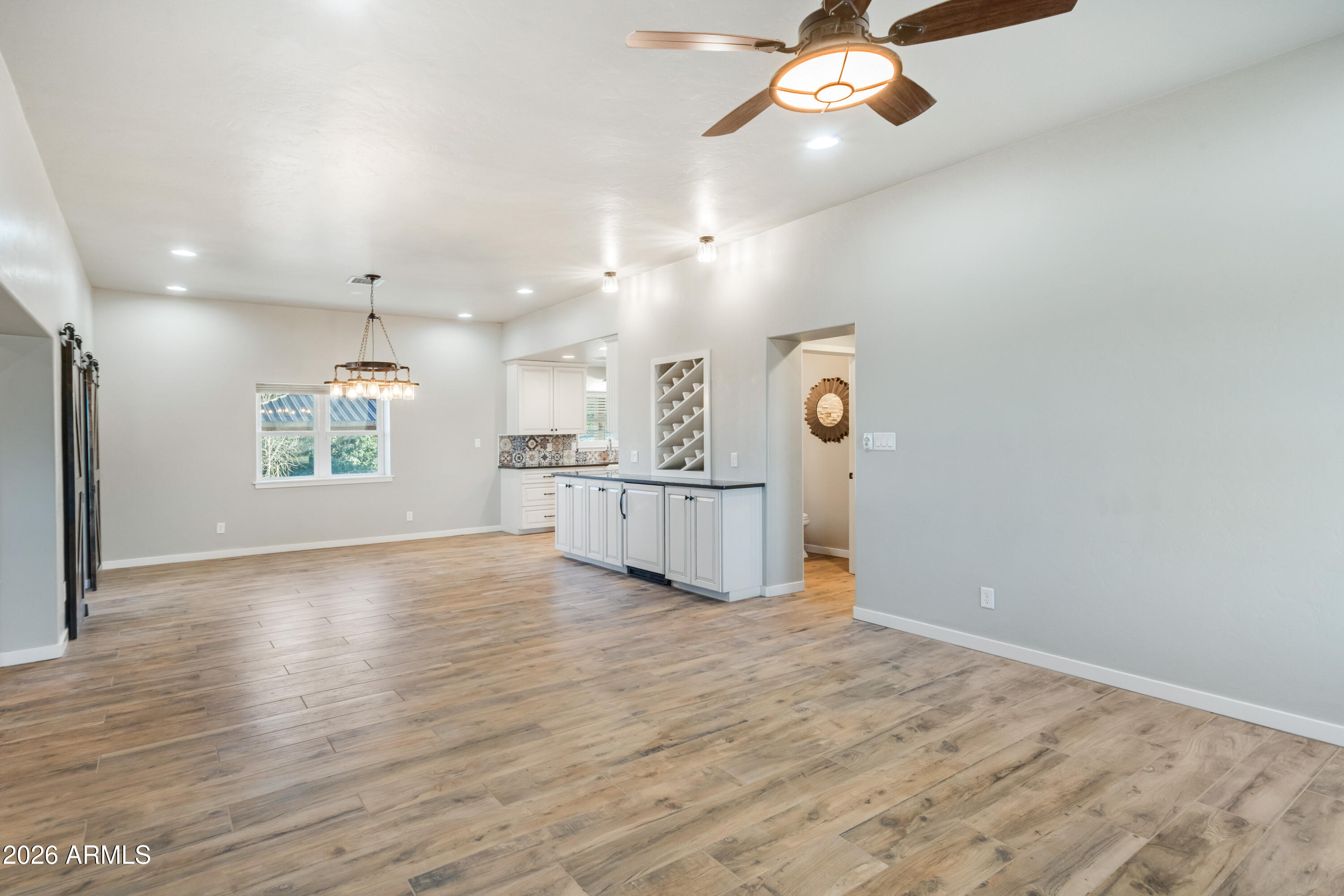 5306 East Spring Road Hereford, AZ 85615 - Photo 12 of 61 an empty room with wooden floor and windows