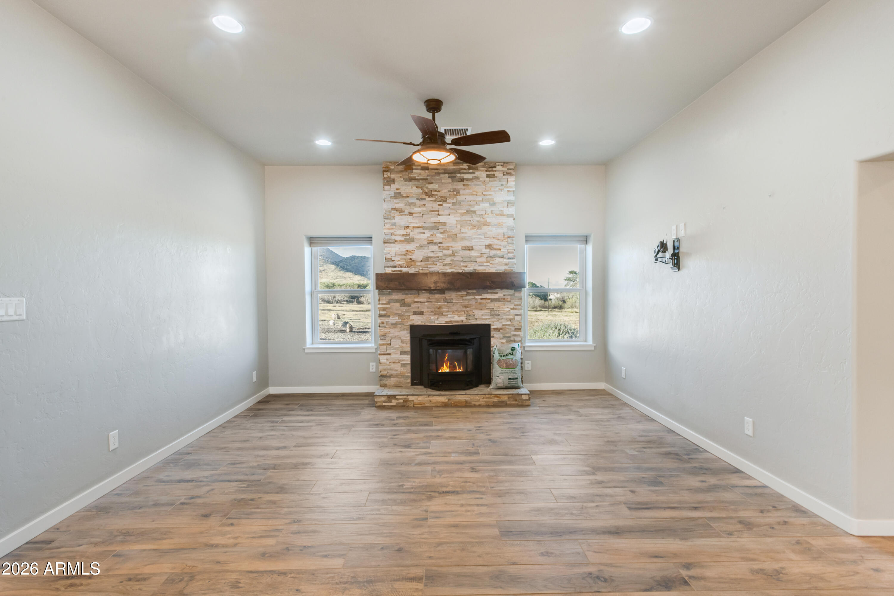 5306 East Spring Road Hereford, AZ 85615 - Photo 16 of 61 a view of a livingroom with a fireplace a chandelier and wooden floor