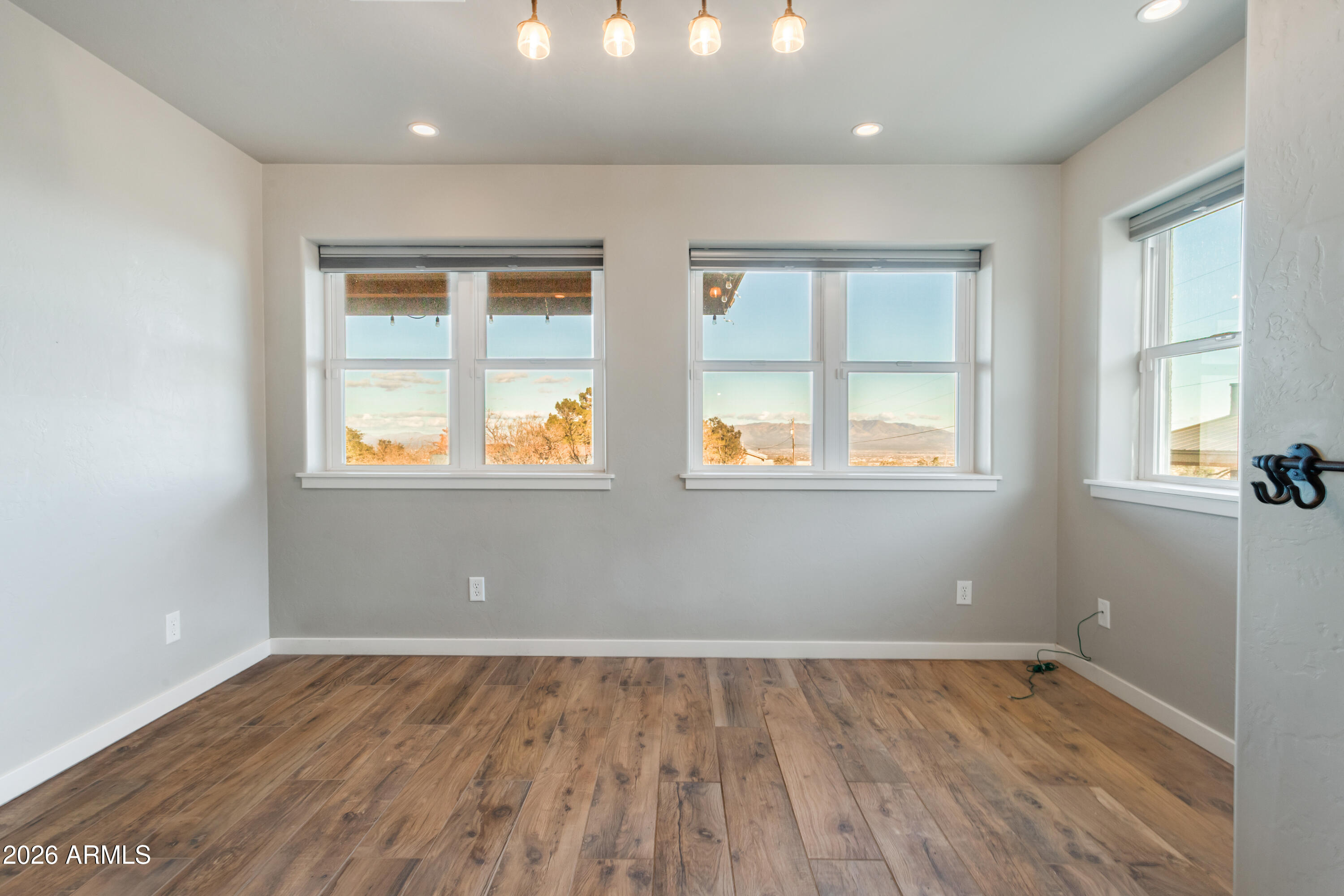 5306 East Spring Road Hereford, AZ 85615 - Photo 18 of 61 an empty room with wooden floor and windows
