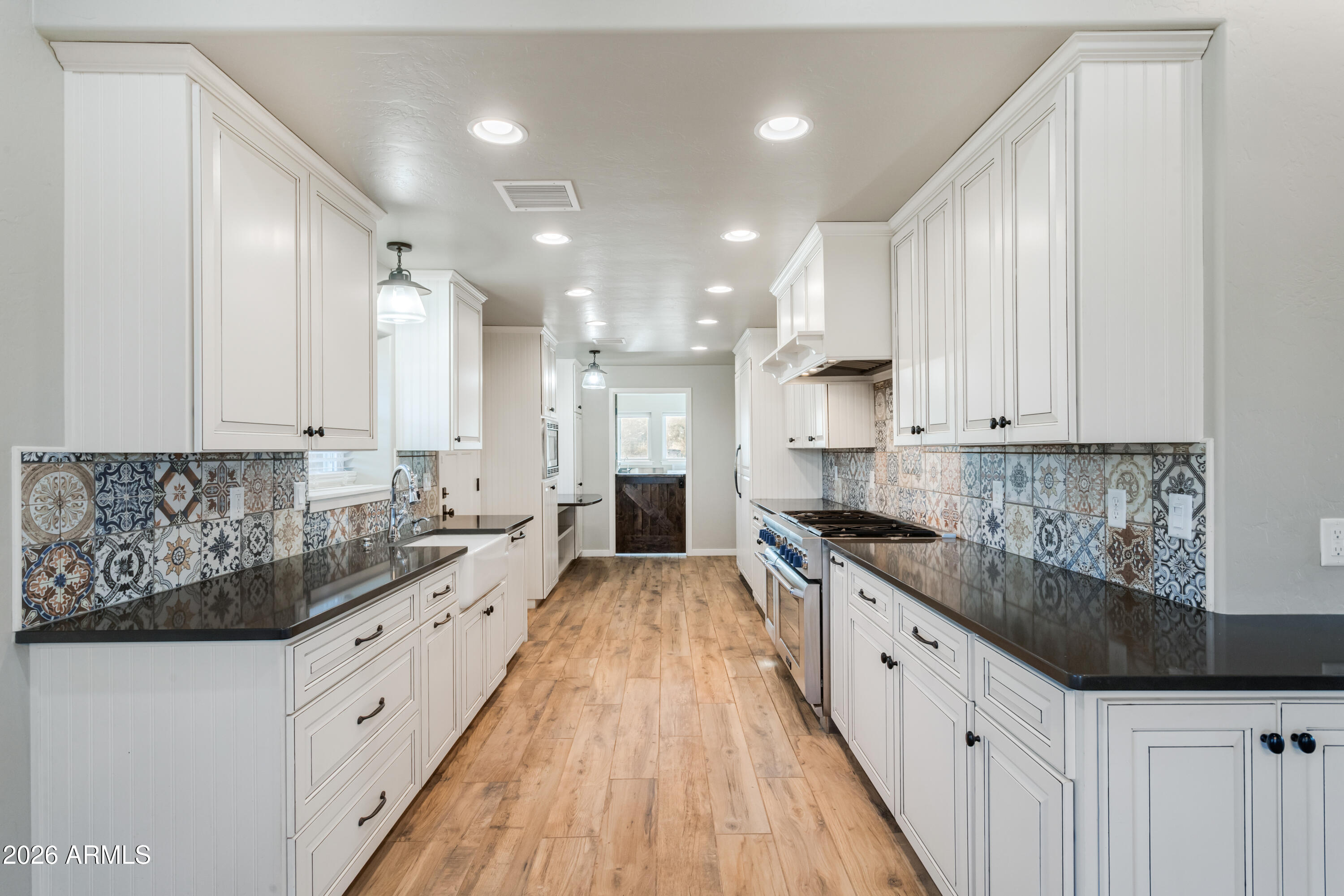 5306 East Spring Road Hereford, AZ 85615 - Photo 20 of 61 a large kitchen with stainless steel appliances lots of counter space and wooden floor