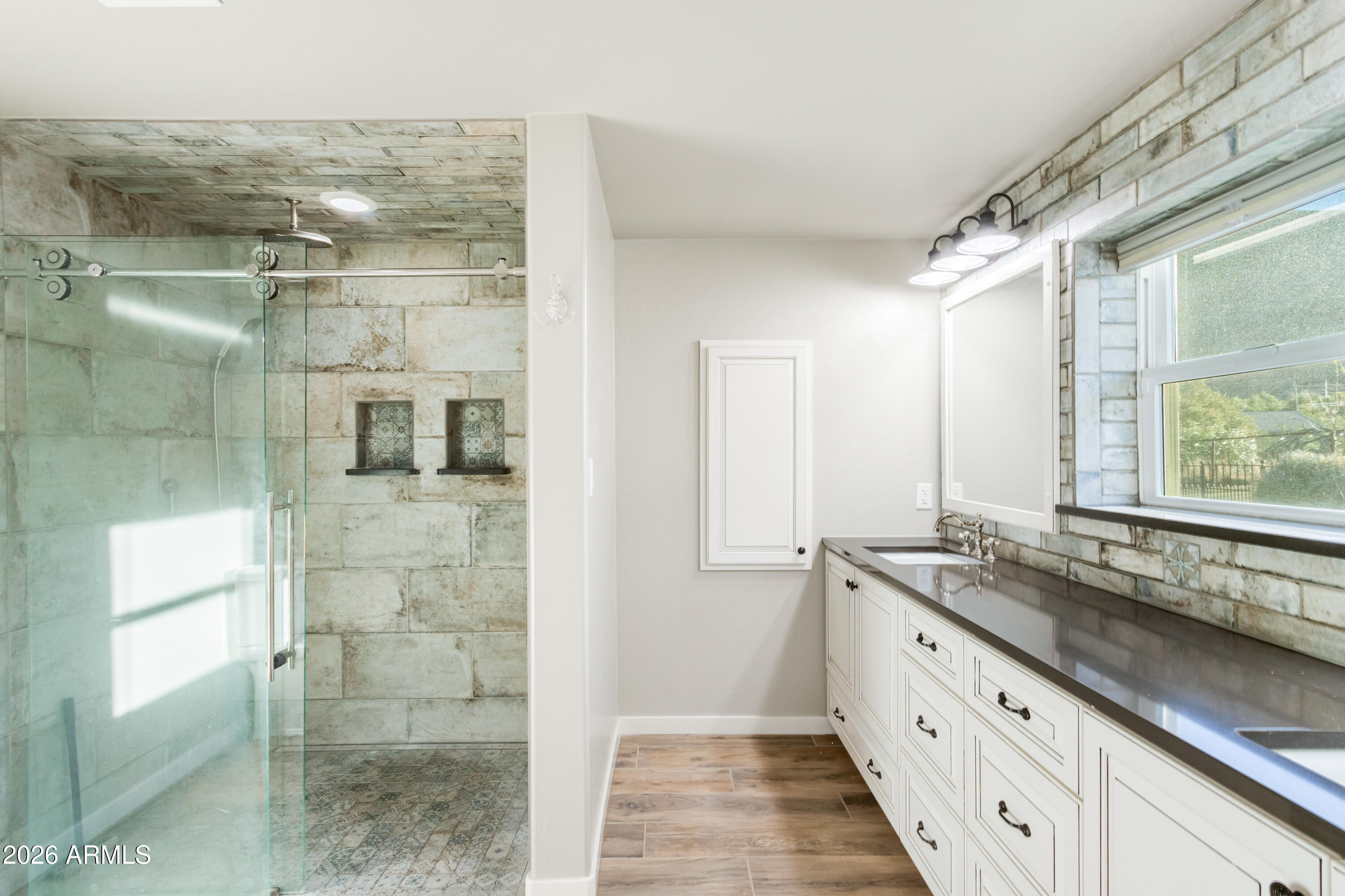 5306 East Spring Road Hereford, AZ 85615 - Photo 29 of 61 a bathroom with a granite countertop sink a mirror and shower