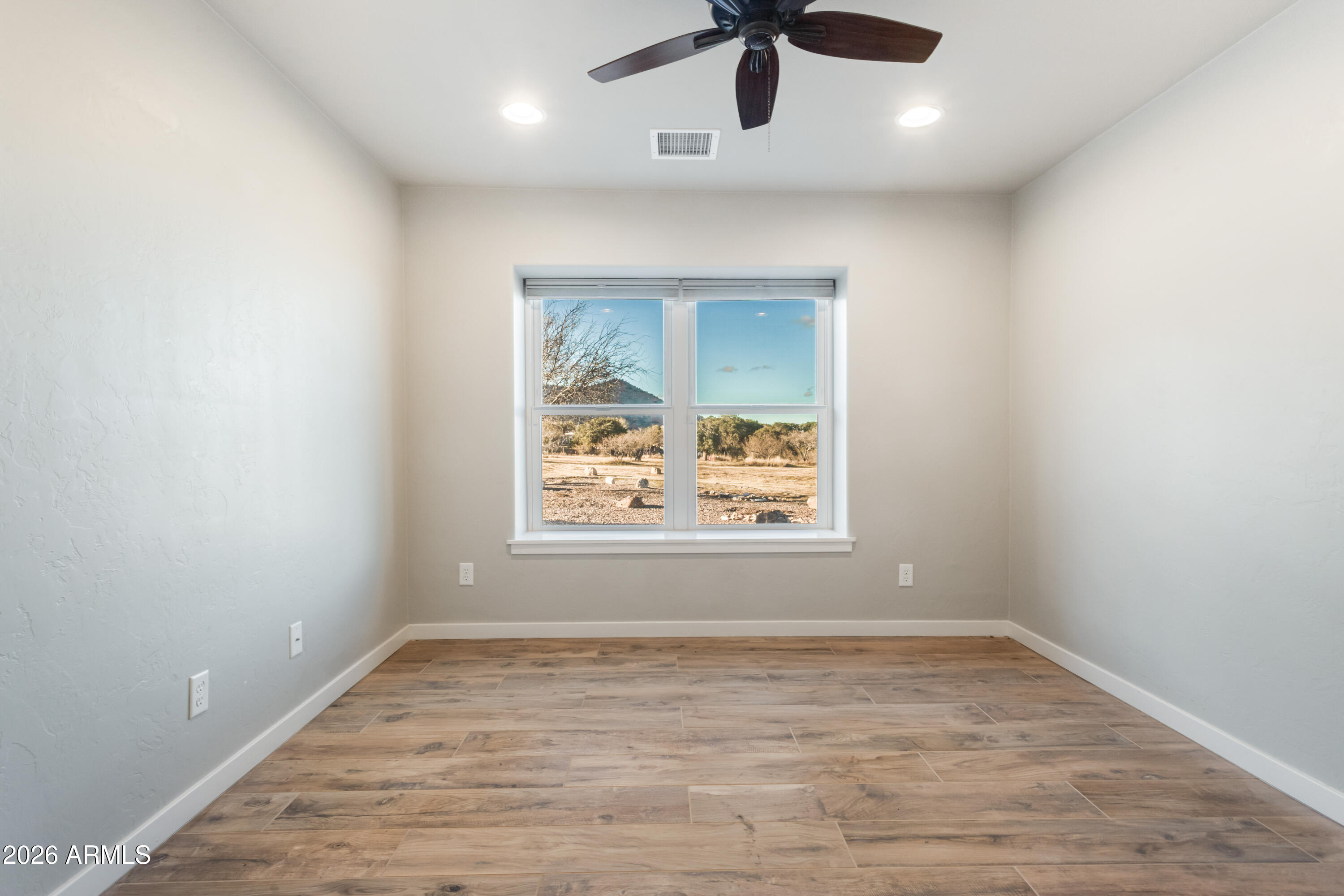 5306 East Spring Road Hereford, AZ 85615 - Photo 32 of 61 an empty room with a window and a ceiling fan
