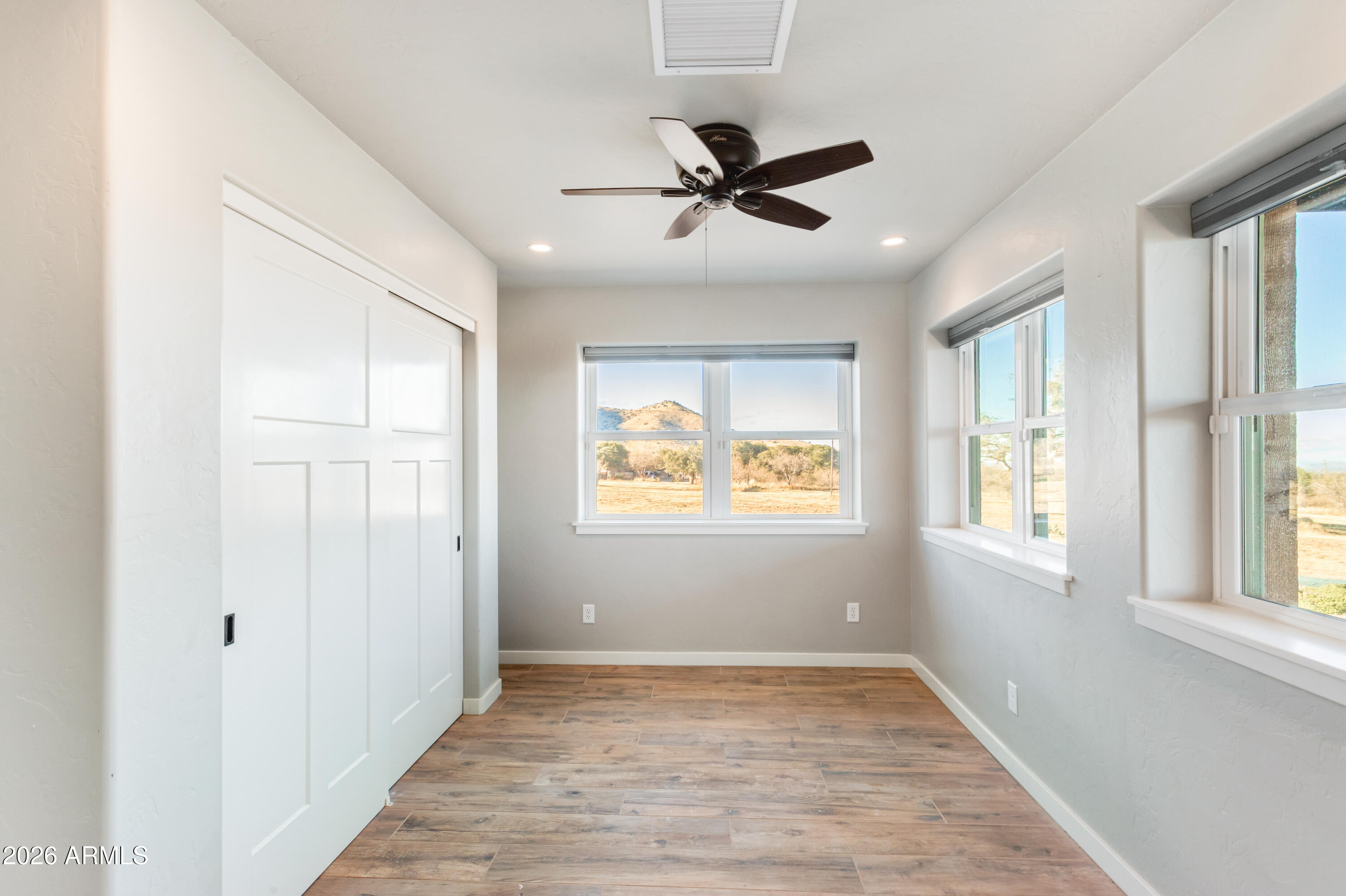 5306 East Spring Road Hereford, AZ 85615 - Photo 7 of 61 a view of an empty room with wooden floor and a window