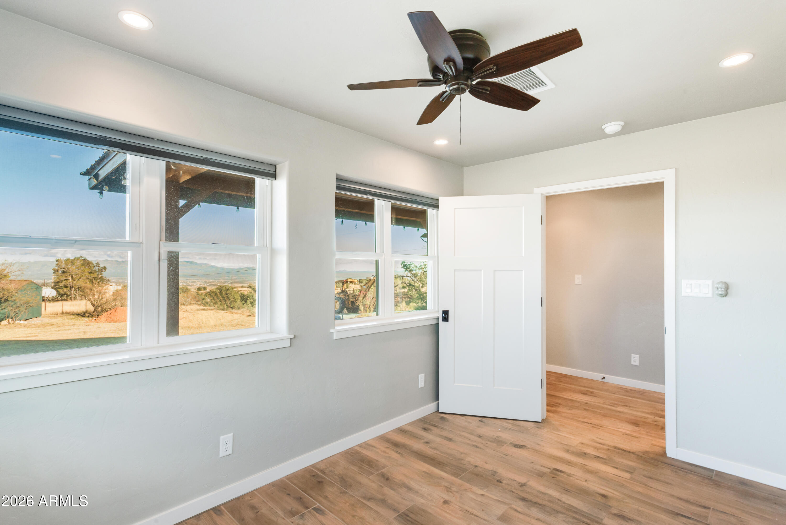 5306 East Spring Road Hereford, AZ 85615 - Photo 8 of 61 a view of an empty room with wooden floor and a window