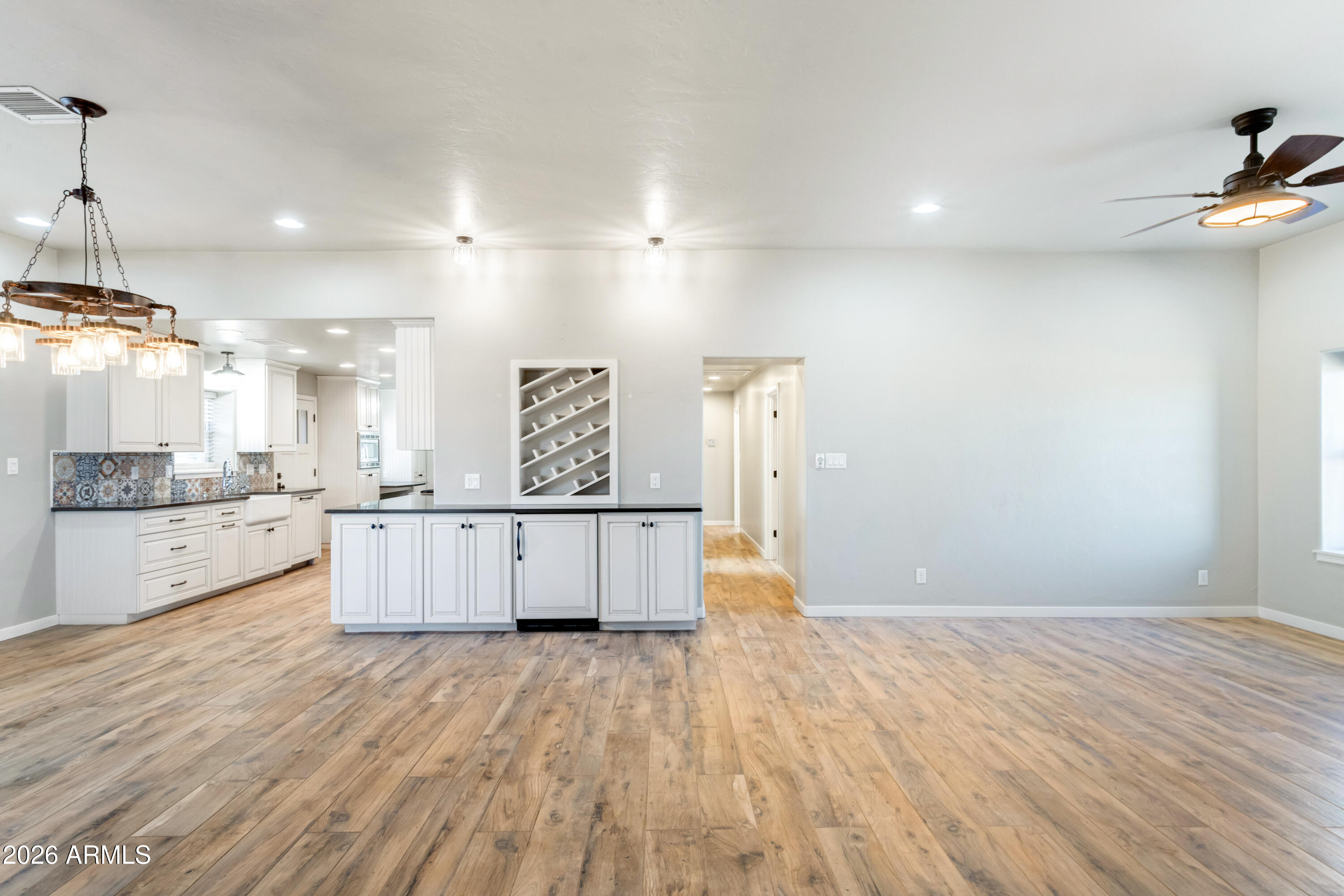5306 East Spring Road Hereford, AZ 85615 - Photo 9 of 61 a large kitchen with stainless steel appliances a large counter top a sink a refrigerator and white cabinets
