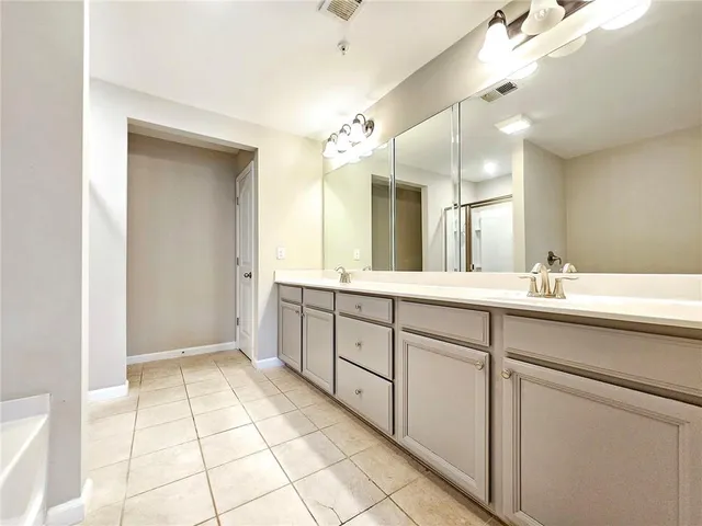 a spacious bathroom with a shower a sink and a mirror
