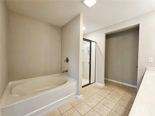 a spacious bathroom with a bathtub and shower