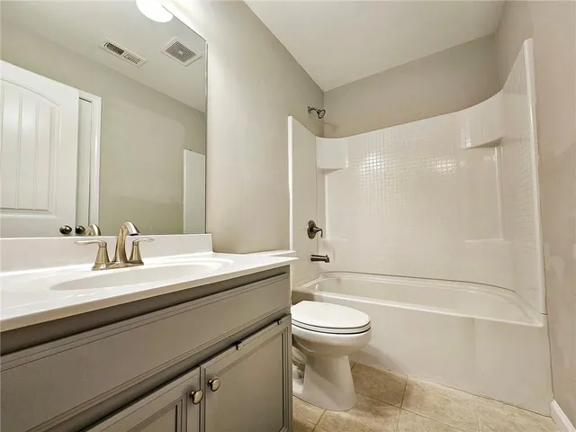 a bathroom with a sink a toilet and a large mirror