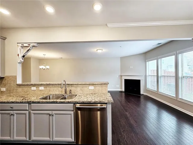 a kitchen with granite countertop a stove a sink and a microwave