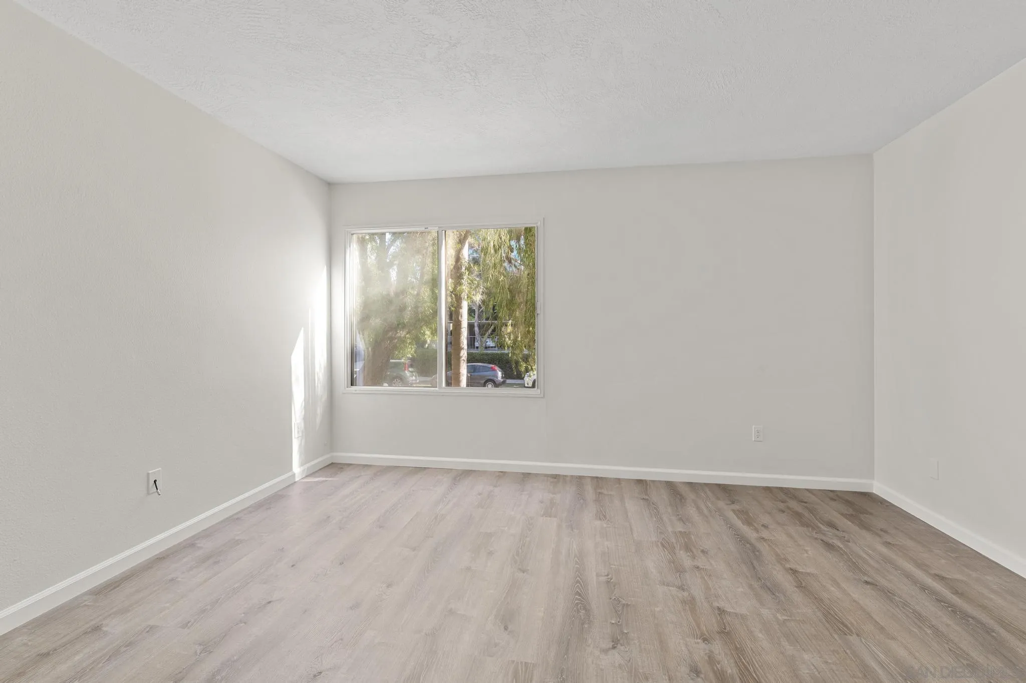 140 Walnut Avenue, Unit 2A San Diego, CA 92103 - Photo 13 of 22 an empty room with wooden floor and windows