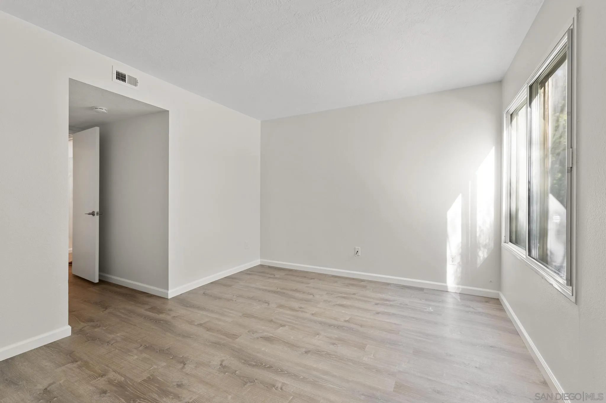 140 Walnut Avenue, Unit 2A San Diego, CA 92103 - Photo 14 of 22 a view of an empty room with wooden floor and a window