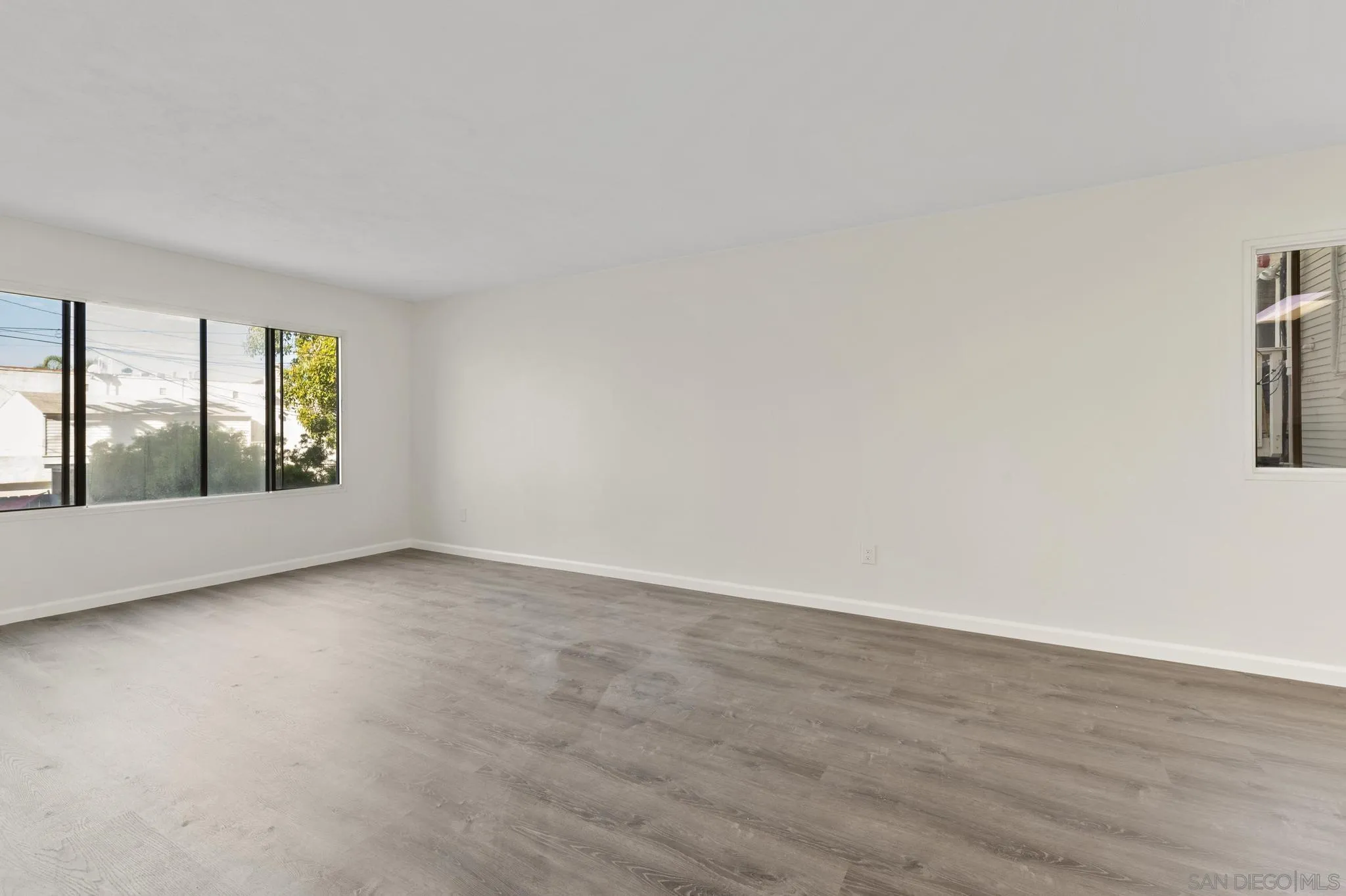 140 Walnut Avenue, Unit 2A San Diego, CA 92103 - Photo 2 of 22 an empty room with wooden floor and windows